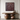 A framed abstract wall art piece in deep burgundy-brown tones hangs above a wooden console table with sculptural wooden side supports and decorative vases in a minimalist interior setting.